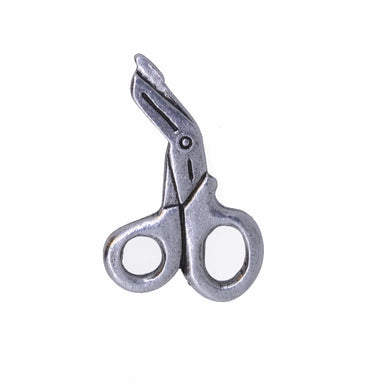 Metallic scissor lapel pin on a white background